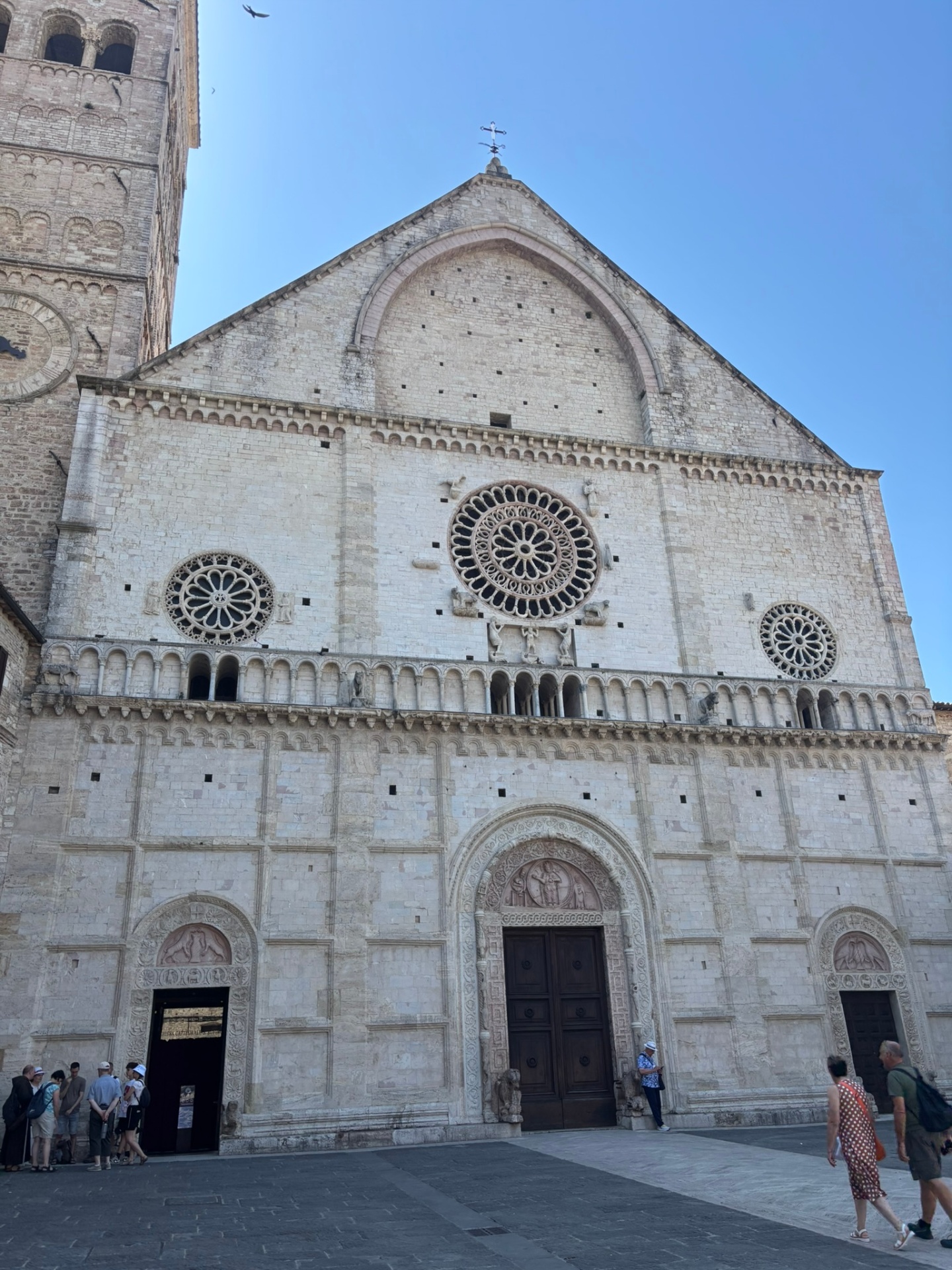 The Romanesque facade of the Cathedral of San Rufino in Assisi with its three rose windows